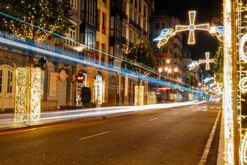 Naklejka na ściany i meble urban landscape illuminated with Christmas decorations and trails of passing vehicles. Oviedo, Asturias, Spain