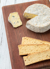 Brazilian artisan Bofete blue cheese with toasts over wooden table