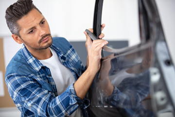 mechanic fitting a door rubber