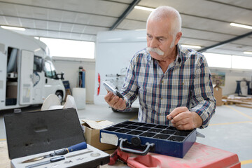 senior man inspecting tools in a garage