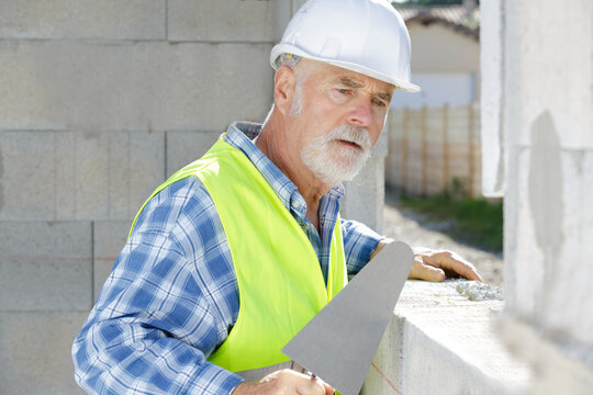senior male bricklayer working outdoors