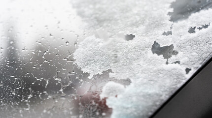 Snow on the windshield of the car. Winter weather for drivers. Snowfall and frost. Winter and road safety.