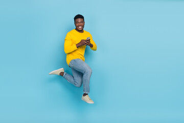 Fototapeta na wymiar Full length photo of funny millennial brunet guy hold telephone run wear smart casual isolated on blue background
