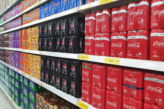 PENANG, MALAYSIA - JULY 11, 2019: Row of various brand carbonated drinks on display in a grocery store. Carbonated drinks are beverages that contain dissolved carbon dioxide.