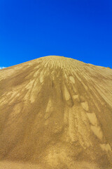 Excavated sand mountains and rubble piles quarry lake dredging pond.