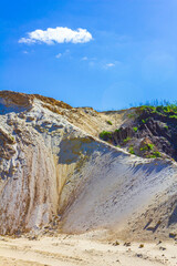 Excavated sand mountains and rubble piles quarry lake dredging pond.
