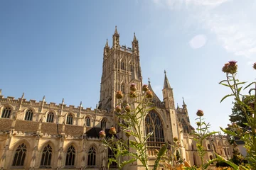 Fotobehang Gloucester Cathedral. England. Side view through lilac flowers © Y.Skybyk