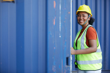 young female factory worker or engineer opening the container door in warehouse storage