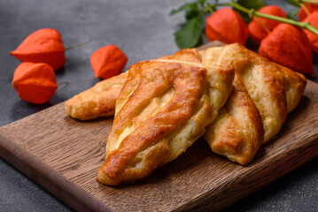 Delicious fresh cornmeal pastries with homemade cheese on a wooden cutting board