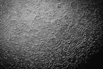 Surface of the moon with impact craters. Model of the moon. Black and white image.