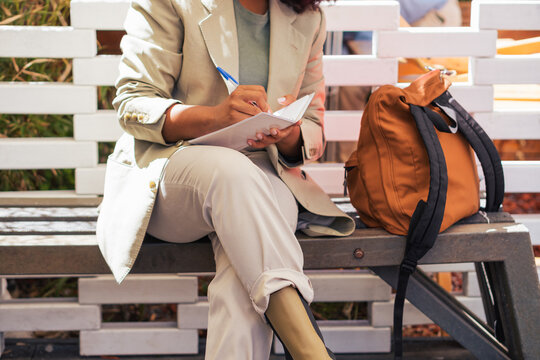 Anonymous black businesswoman making notes on street
