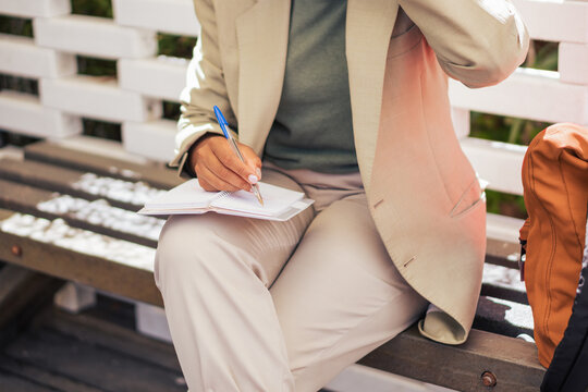 Anonymous black businesswoman making notes on street