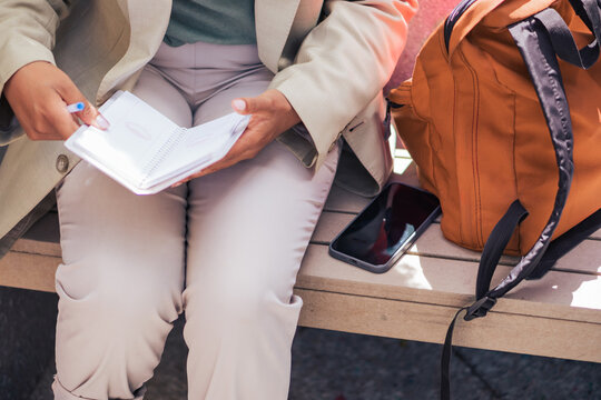 Anonymous black businesswoman making notes on street