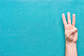 three fingers on man hand on glitter aquamarine background