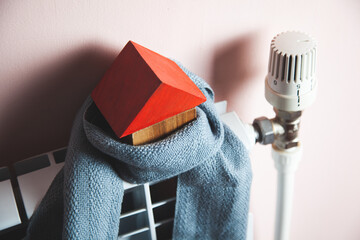 Model of a house in a scarf on a radiator indoors