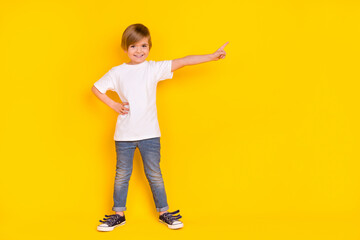 Full length body size view of handsome cheery pre-teen boy dancing showing copy space isolated over vivid yellow color background