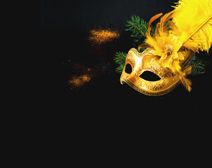 Masquerade mask on black background with confetti. New Years decor. Blurred effect. Close-up