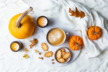 Obraz na płótnie Canvas Fall cozy holiday background with cup of coffee, cookies, pumpkins and wool knitted plaid. Warm autumn mood flat lay. Breakfast in bed
