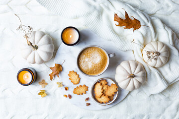 Fototapeta na wymiar Fall cozy holiday background with cup of coffee, cookies, pumpkins and wool knitted plaid. Warm autumn mood flat lay. Breakfast in bed