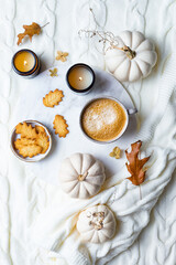 Obraz na płótnie Canvas Fall cozy holiday background with cup of coffee, cookies, pumpkins and wool knitted plaid. Warm autumn mood flat lay. Breakfast in bed