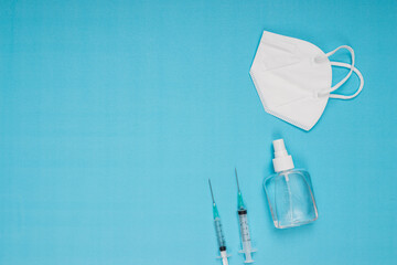 disinfectant, needle, vaccine, mask standing on blue background