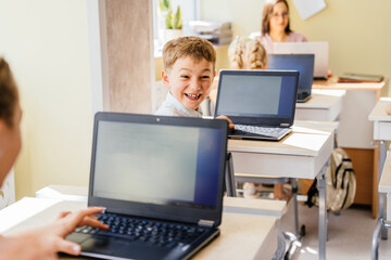 Cute smiling pupil boy during Informatics class. Internet technology. Modern education concept Modern education internet technologies concept.