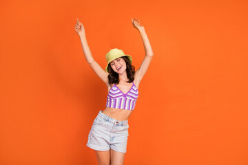 Fototapeta na wymiar Photo of lucky sweet woman dressed violet bra smiling rising fists having fun isolated orange color background