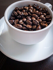 close up of a cup with brown coffee grains, upright	