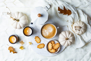 Fall cozy holiday background with cup of coffee, cookies, pumpkins and wool knitted plaid. Warm autumn mood flat lay.  Breakfast in bed