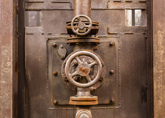 Valves, copper pipes. Old stove. Industrial, metal, mechanical factory background. Loft