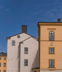 Facades of old 1700s court houses a sunny day with cumulus clouds in Stockholm