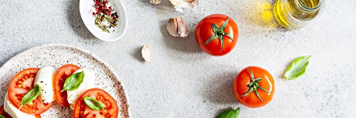 Caprese salad with juicy tomatoes, fresh mozzarella and pesto. Concept for a tasty and healthy...