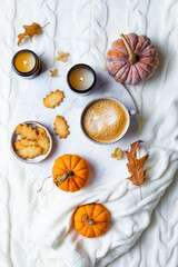 Fall cozy holiday background with cup of coffee, cookies, pumpkins and wool knitted plaid. Warm autumn mood flat lay.  Breakfast in bed