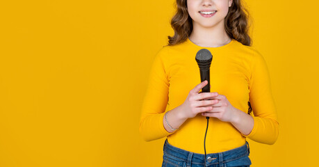 cropped view of teen girl with microphone on yellow background