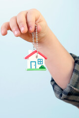 Boy is Looking to a House Key Against Blue Background