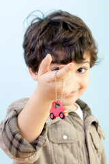 Boy is Offering Us a Car Key Against Blue Background