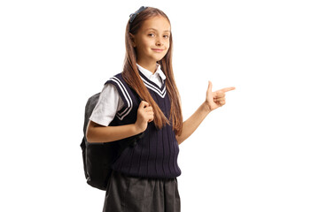 Schoolgirl with a backpack and a uniform pointing to the side - obrazy, fototapety, plakaty
