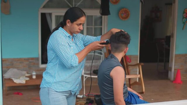mom giving haircut to her son, latin family, medium shot