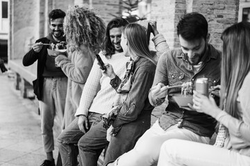 Happy young friends eating take away food outdoor - Focus on girl head holding mobile phone - Black and white editing