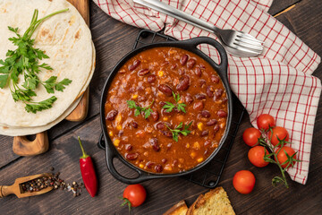 Bean and corn soup or ragout, red bean stew on a wood background