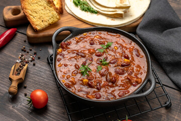 Bean and corn soup or ragout, red bean stew on a wood background