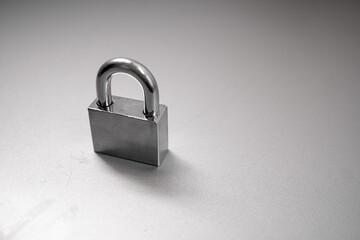 Naklejka premium Silver key locked on stainless steel background. Lock with keys on stainless steel background.