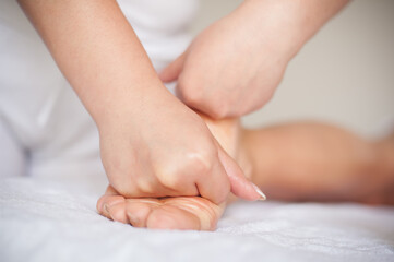 Professional therapist giving traditional thai foot massage to a woman in spa