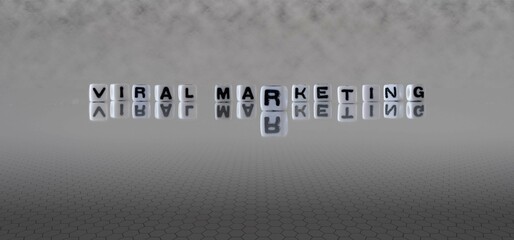 viral marketing word or concept represented by black and white letter cubes on a grey horizon background stretching to infinity