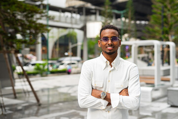 Portrait of young handsome stylish black man in city