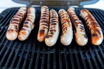 Pork - beef sausages on grill in the summer garden