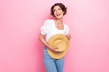 Photo of adorable thoughtful lady wear white blouse holding straw headwear looking empty space...