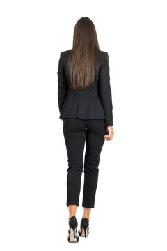 Elegant woman in business black suit walking away. Back view isolated on transparent background.	
