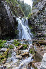 Fototapeta na wymiar Waterfall in a mountain gorge