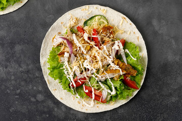 Flatbread, Tortilla with chicken meat, lettuce, tomatoes, cheese, sauce. Easy to cook sandwich. Healthy snack, top view.